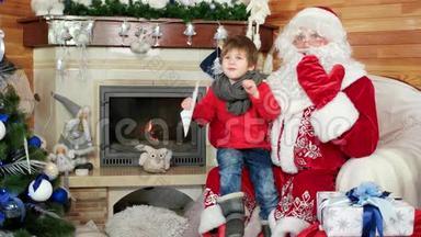 小男孩坐在圣诞老人`腿上，小男孩带着圣诞<strong>信访</strong>问圣尼古拉斯冬季住宅